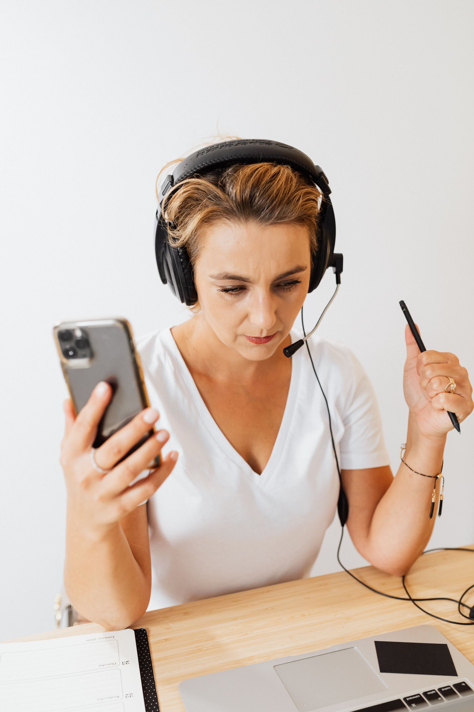 A virtual assistant wearing a headset, working from her laptop and phone